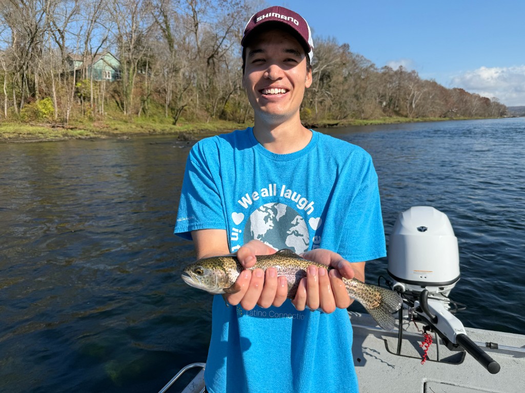 Holding a rainbow trout caught while fly fishing on a river