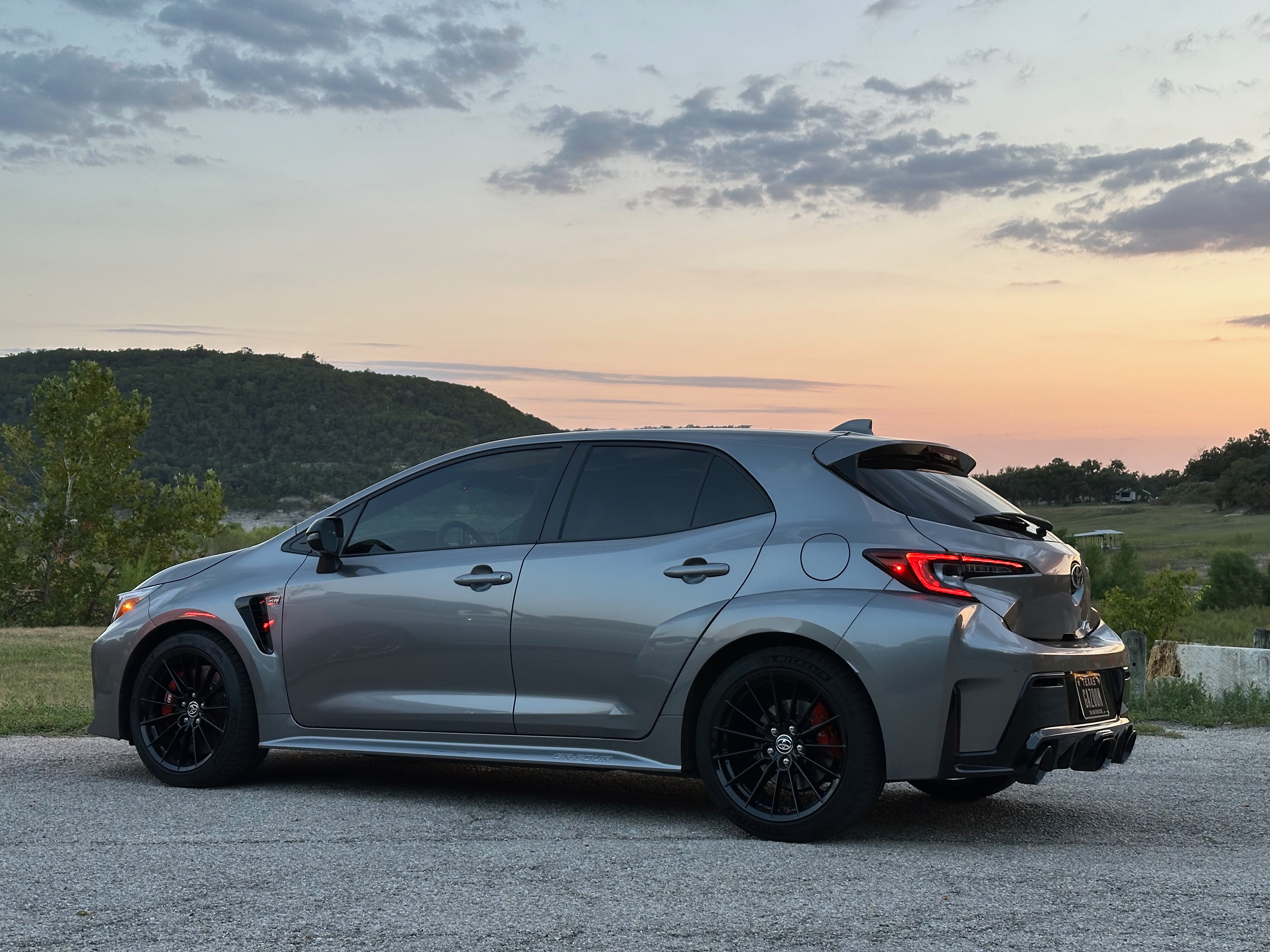 Side profile of the GR Corolla parked at sunset overlooking the hills