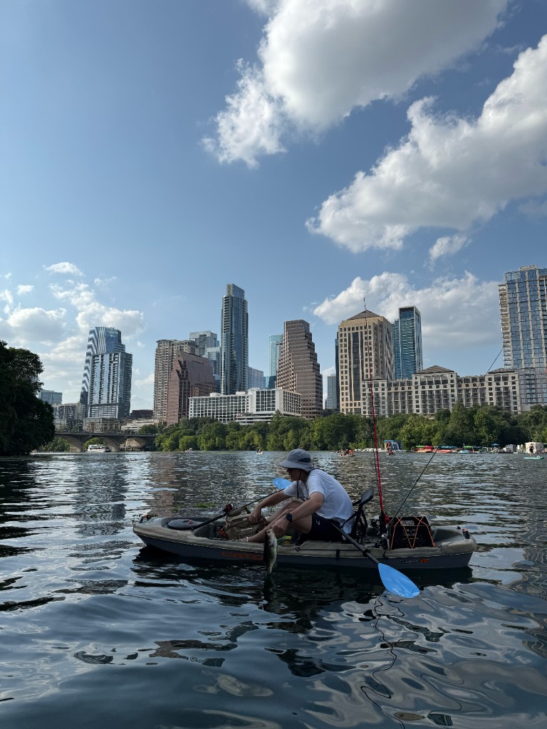 Releasing a bass back into Town Lake with downtown Austin in the background